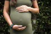 Pregnant woman gently holding her belly, showing maternal care and nourishment during pregnancy—support your journey with WeNatal prenatal supplements for optimal nutrition. - WeNatal prenatal
